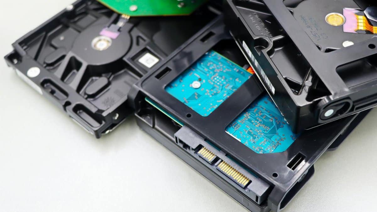 Stack of internal hard disk drives for digital storage on white background.