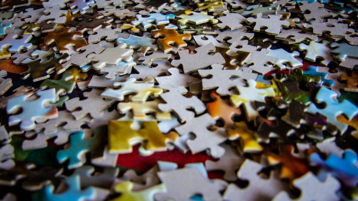 A colorful collection of jigsaw puzzle pieces scattered on a flat surface, ideal for hobby and leisure themes.