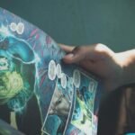 Close-up shot of hands holding a colorful superhero comic book in a sunlit room, depicting leisure reading.