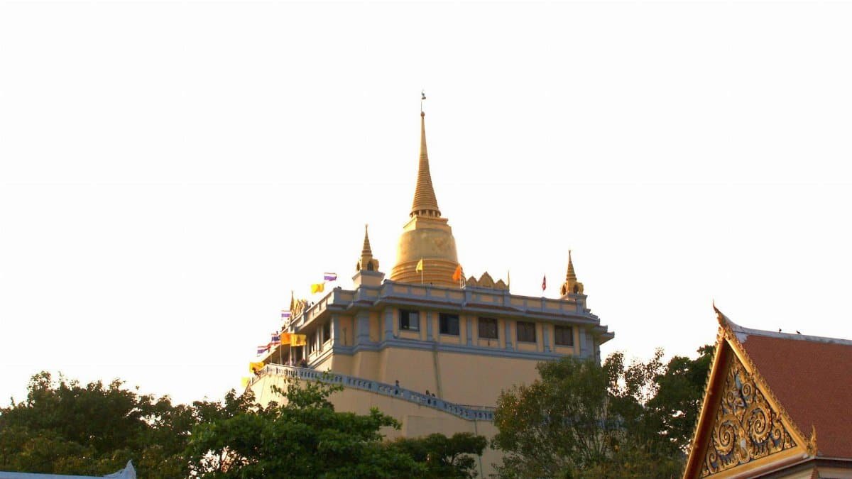A striking view of the Golden Mount Temple in Bangkok, beautifully illuminated by the sunset.