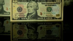 Detailed photo of a ten dollar bill with a clear reflection beneath it.