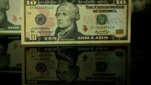 Detailed photo of a ten dollar bill with a clear reflection beneath it.