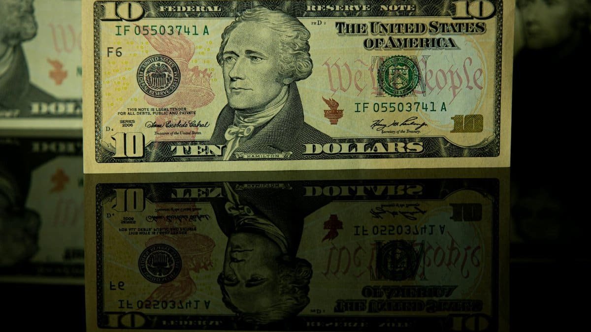 Detailed photo of a ten dollar bill with a clear reflection beneath it.