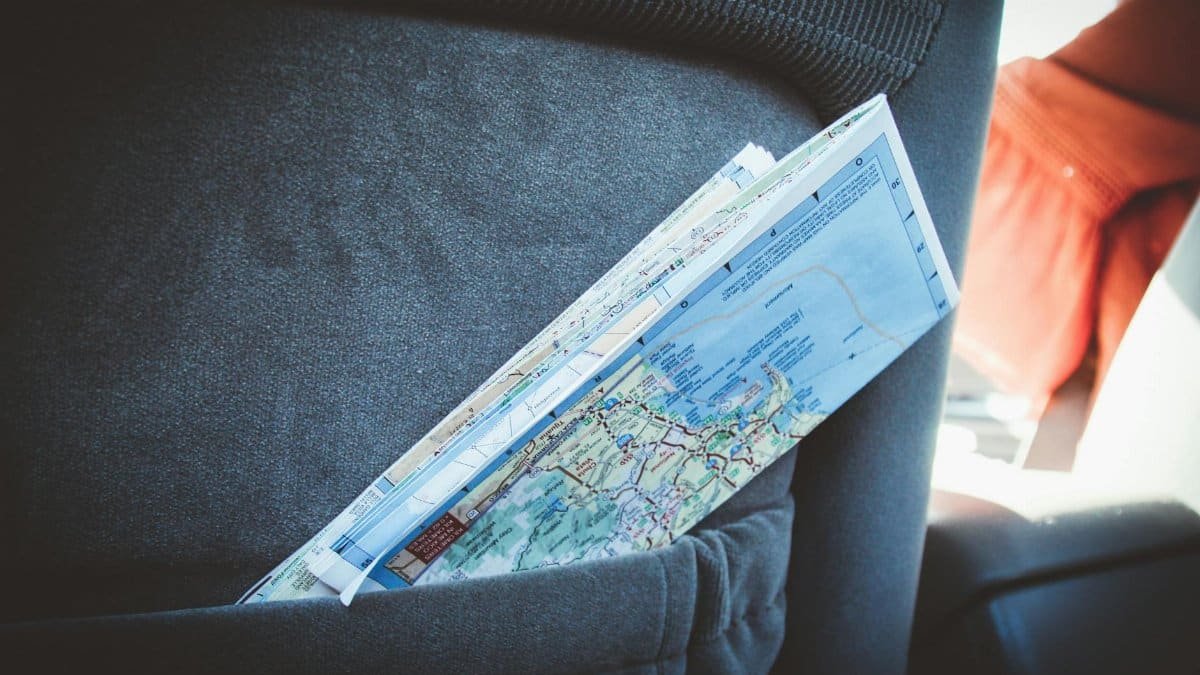 A folded map in a car seat pocket, perfect for planning a road trip.