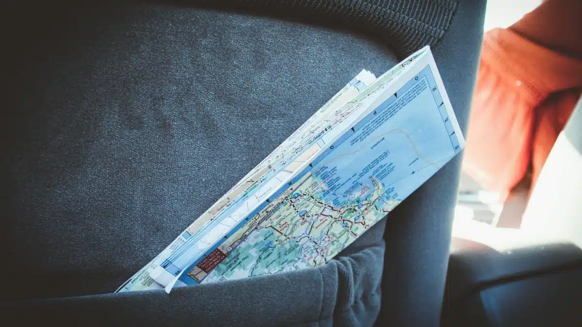 A folded map in a car seat pocket, perfect for planning a road trip.