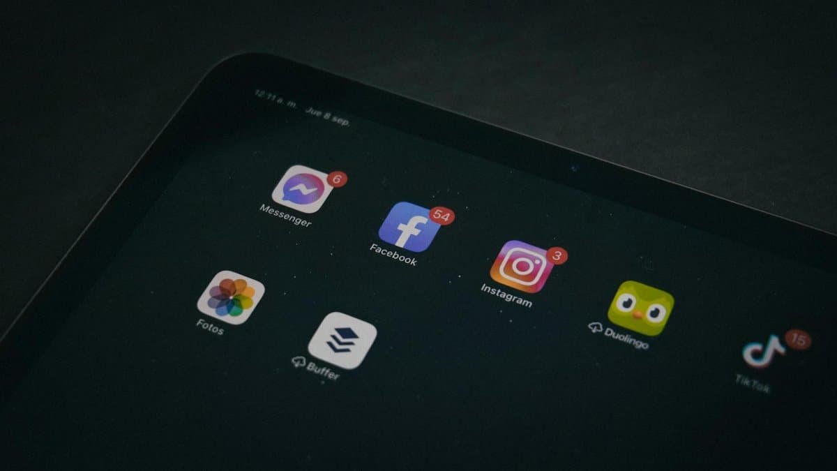 A tablet displaying popular apps like Facebook and Instagram in a dimly lit setting.