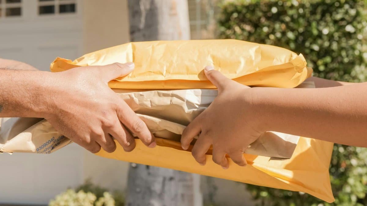 Close-up of two hands exchanging packages, symbolizing delivery and communication.