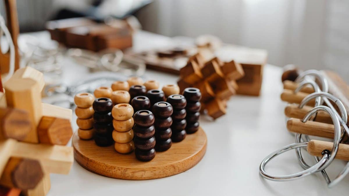 Close-up of various wooden brain teaser puzzles arranged on a table indoors.