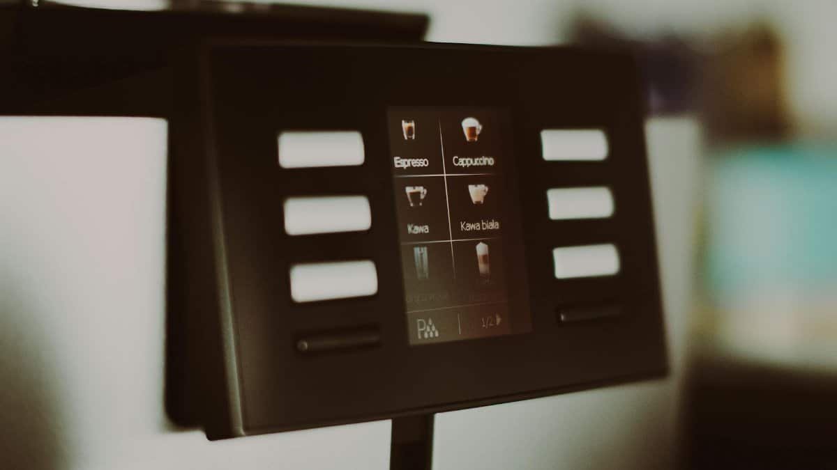 Close-up of a digital coffee machine display showcasing espresso and cappuccino options.