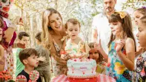 A lively outdoor children's birthday party with cake, family, and friends in a joyful atmosphere.