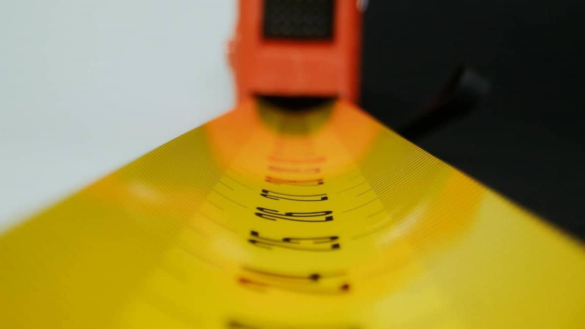Detailed view of a yellow tape measure with selective focus on numbers.