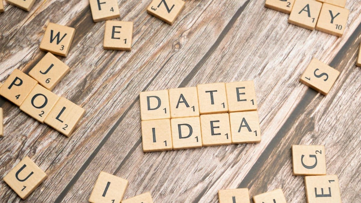 Letter tiles spelling 'Date Idea' on a wooden surface, suggesting creative meeting plans.