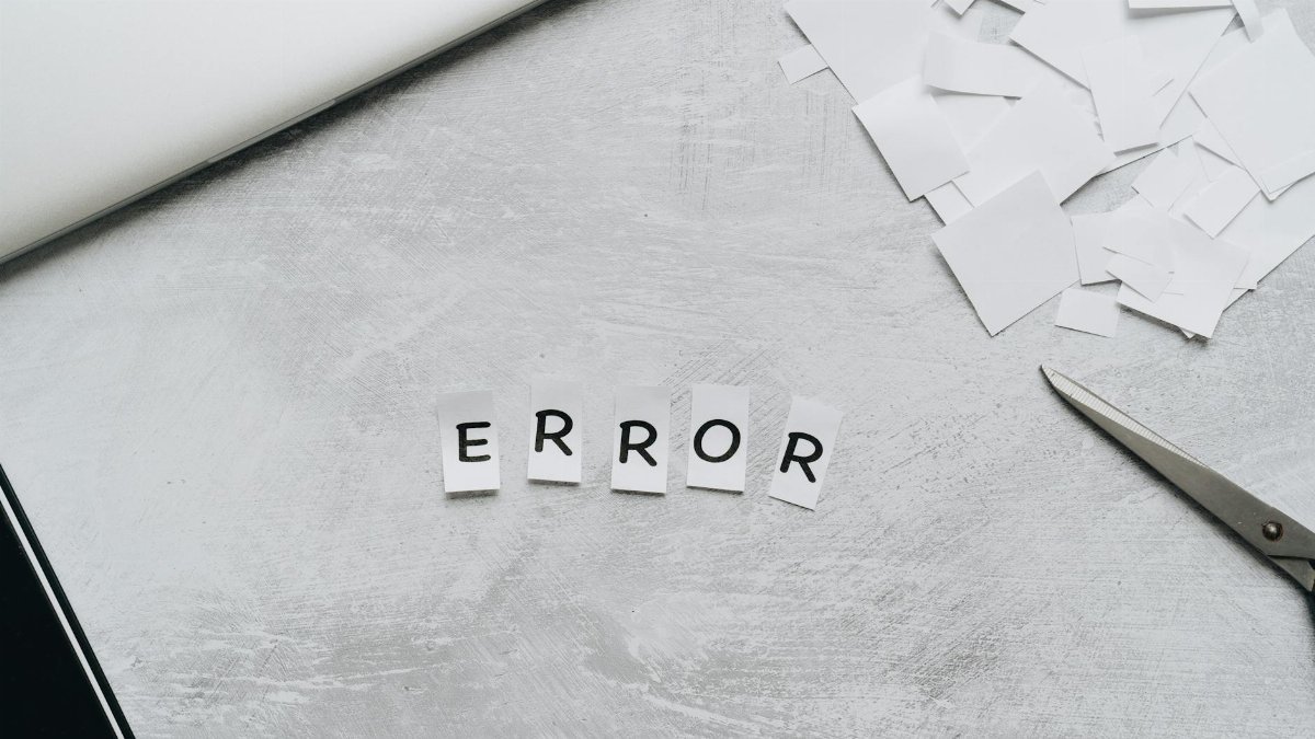 Creative concept showing the word 'error' with cut out letters on a table with scissors and paper.