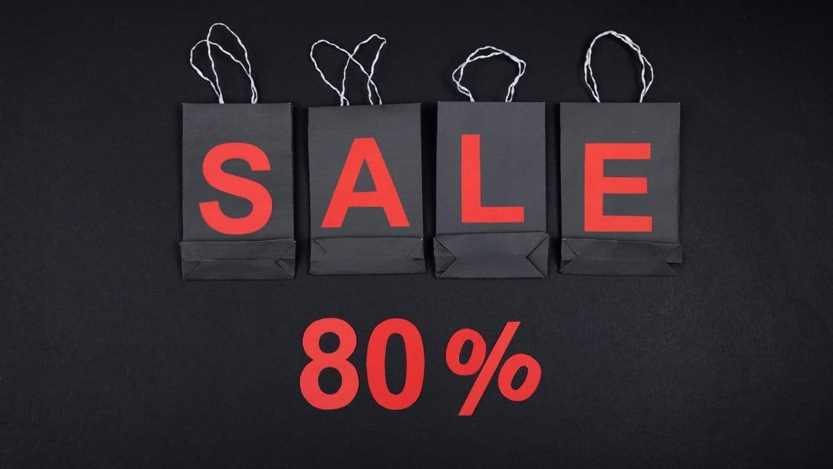 Highlighting a sale with 80% discount using black shopping bags and bold red text.