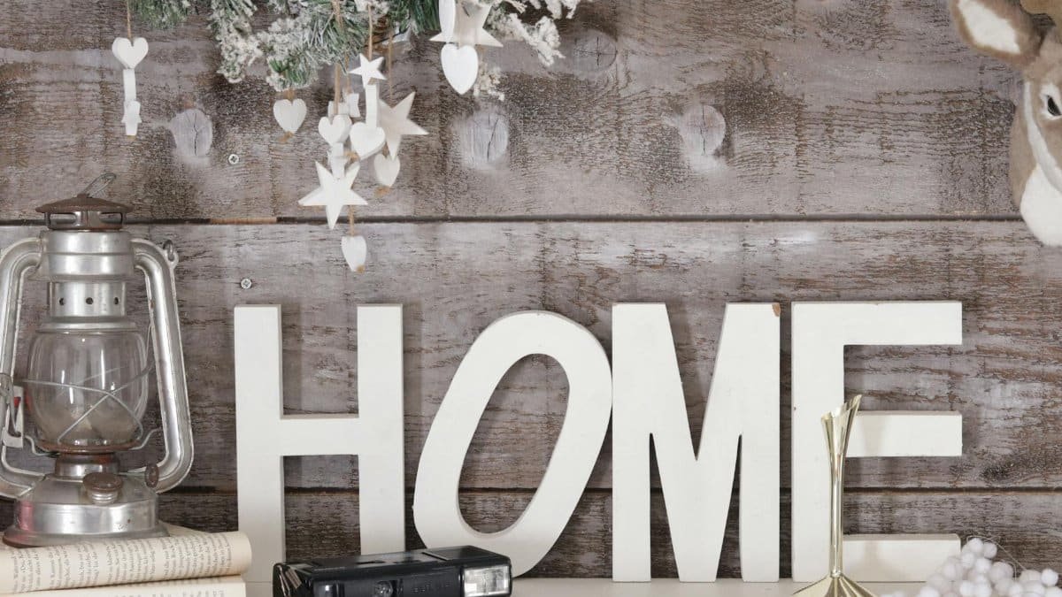 Warm and rustic home decor featuring a vintage lantern, wooden letters, and festive decorations.