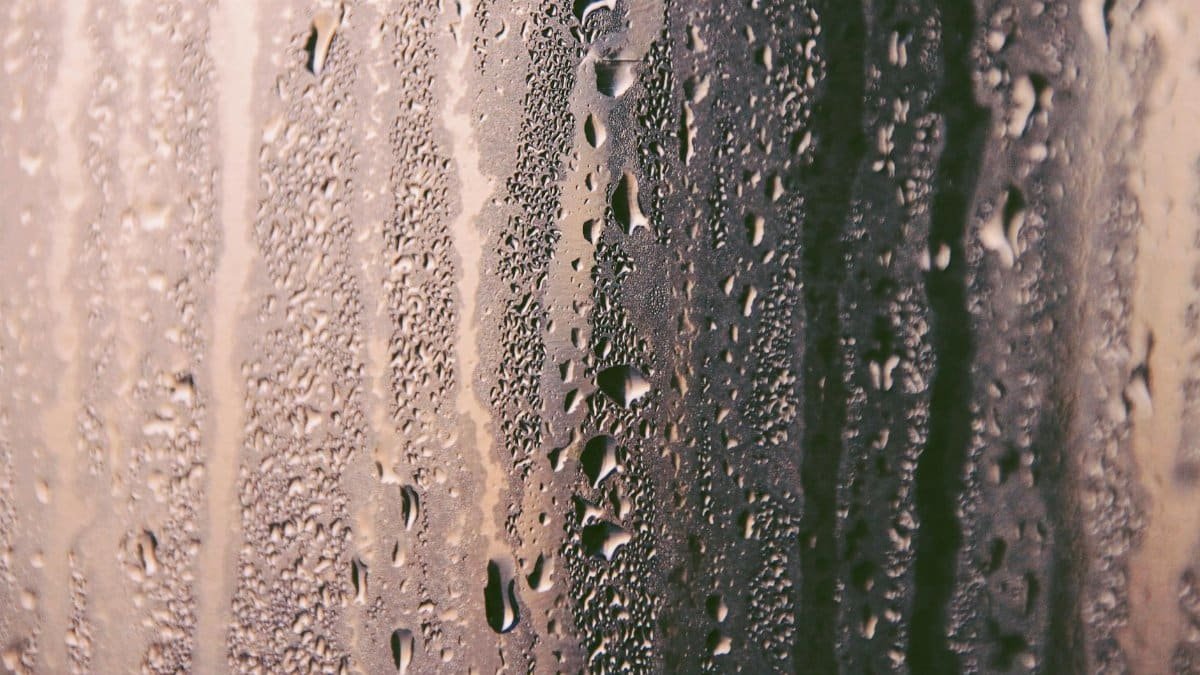 A detailed abstract image showcasing dewdrops on a glass surface, creating a textured pattern.