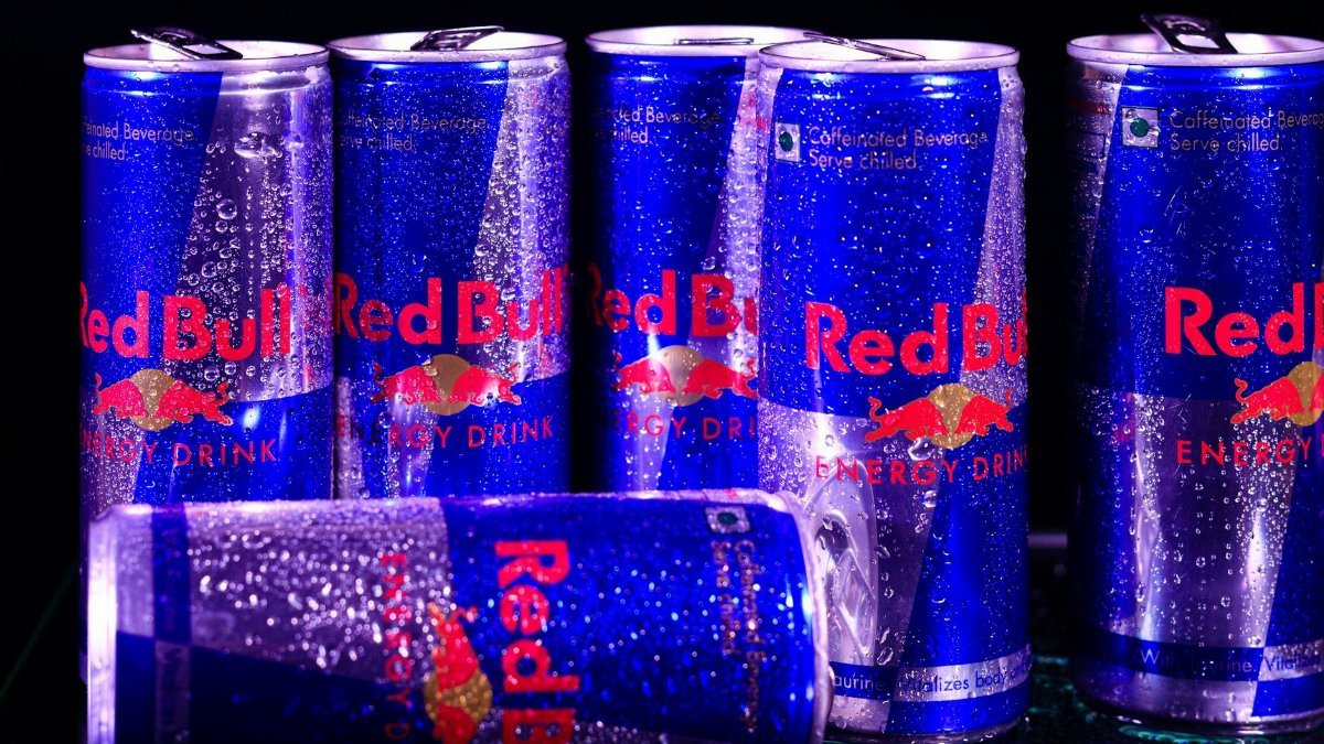 Close-up shot of chilled Red Bull energy drink cans with droplets.