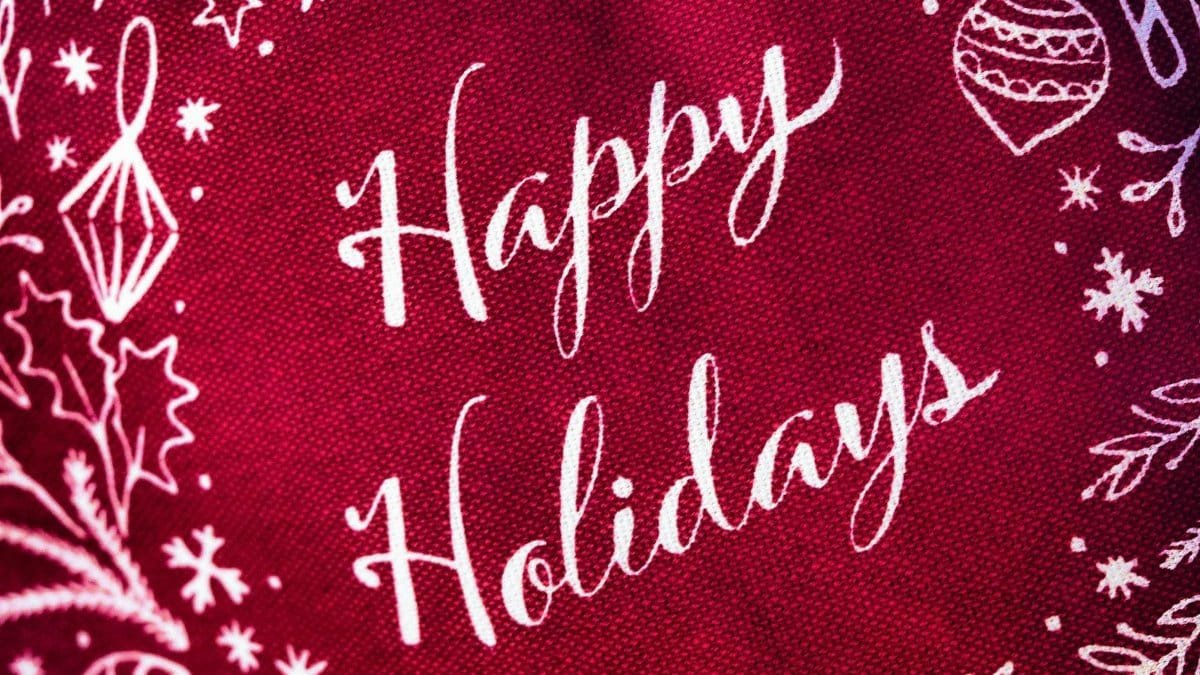 Bright red fabric with white 'Happy Holidays' and festive decorations for a cheerful holiday vibe.