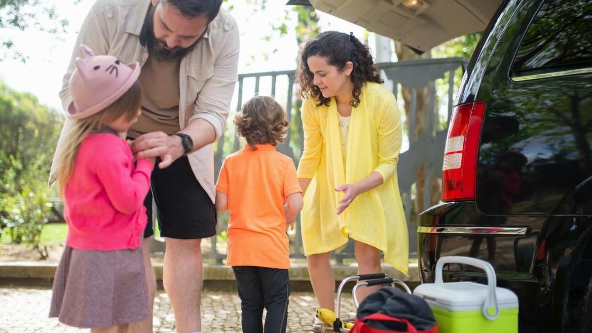 Cheerful family preparing car for a day trip in sunny Portugal.