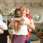 A heartwarming reunion with family members hugging and smiling in a cozy indoor setting.