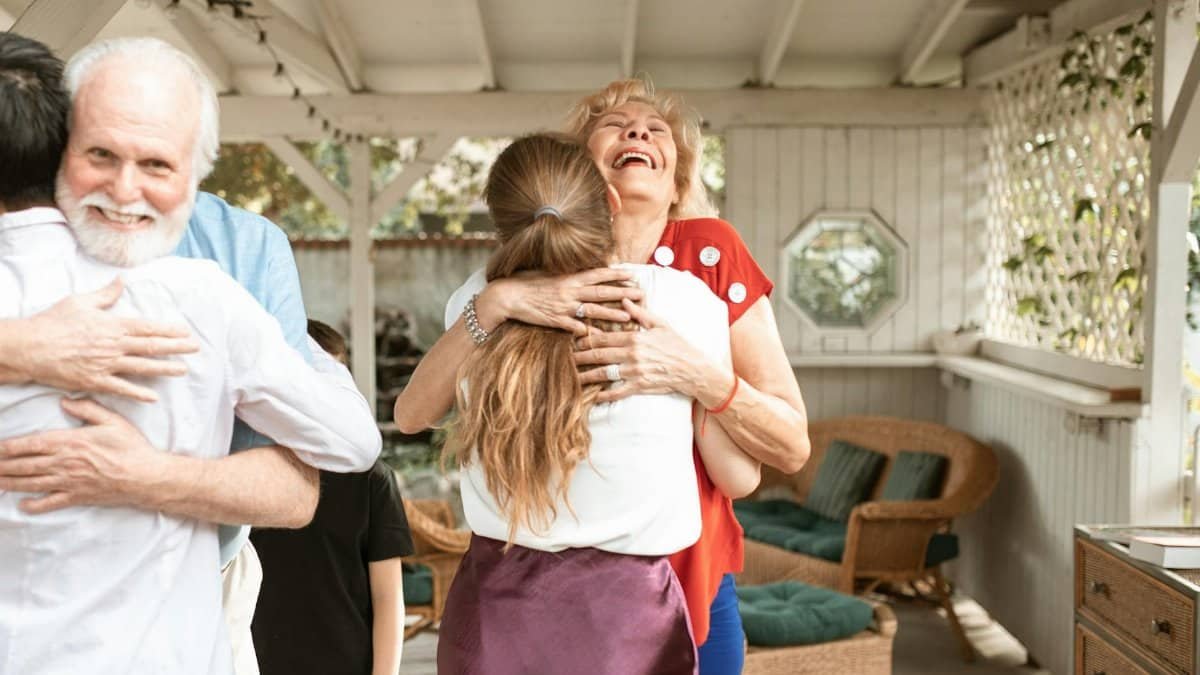 A heartwarming reunion with family members hugging and smiling in a cozy indoor setting.
