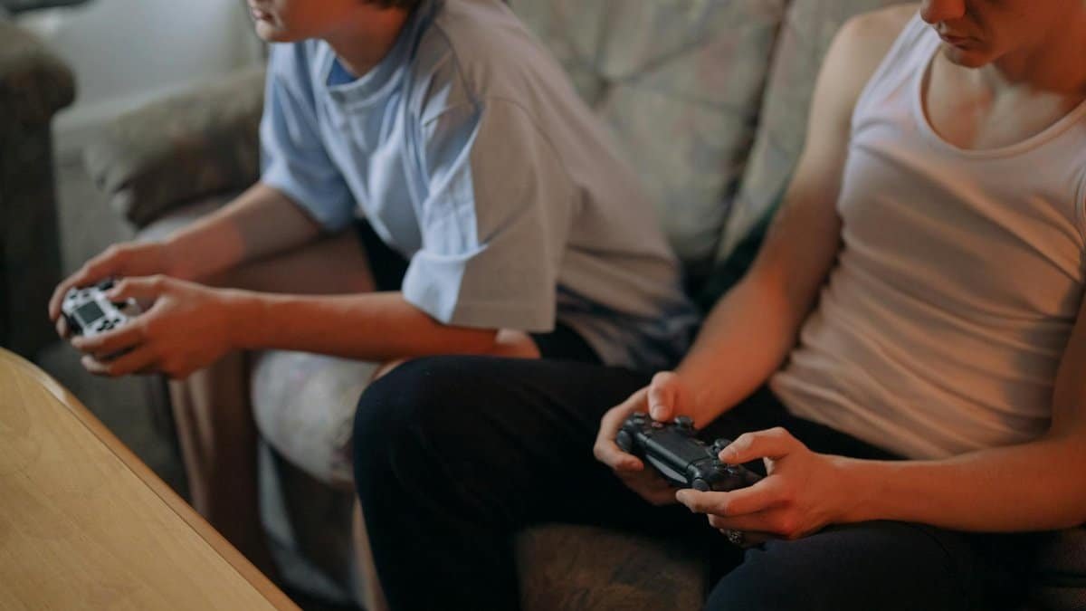 Two brothers bonding over video games in a cozy living room setting.