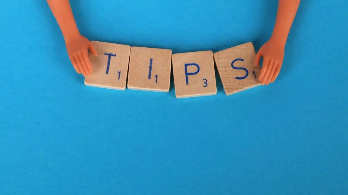 Scrabble tiles spelling 'TIPS' on a blue background, ideal for creative concepts.