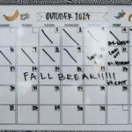 Close-up of a whiteboard calendar for October 2024 featuring a fall break note.