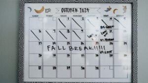 Close-up of a whiteboard calendar for October 2024 featuring a fall break note.