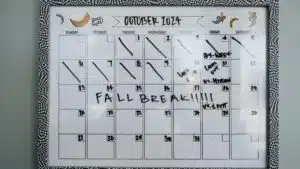 Close-up of a whiteboard calendar for October 2024 featuring a fall break note.