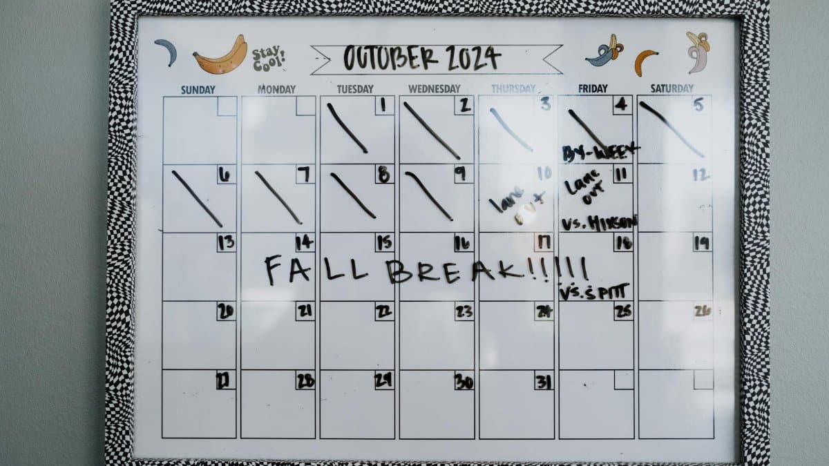 Close-up of a whiteboard calendar for October 2024 featuring a fall break note.