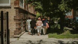 A diverse group of women walking together on a sunny day in a Chicago neighborhood street.