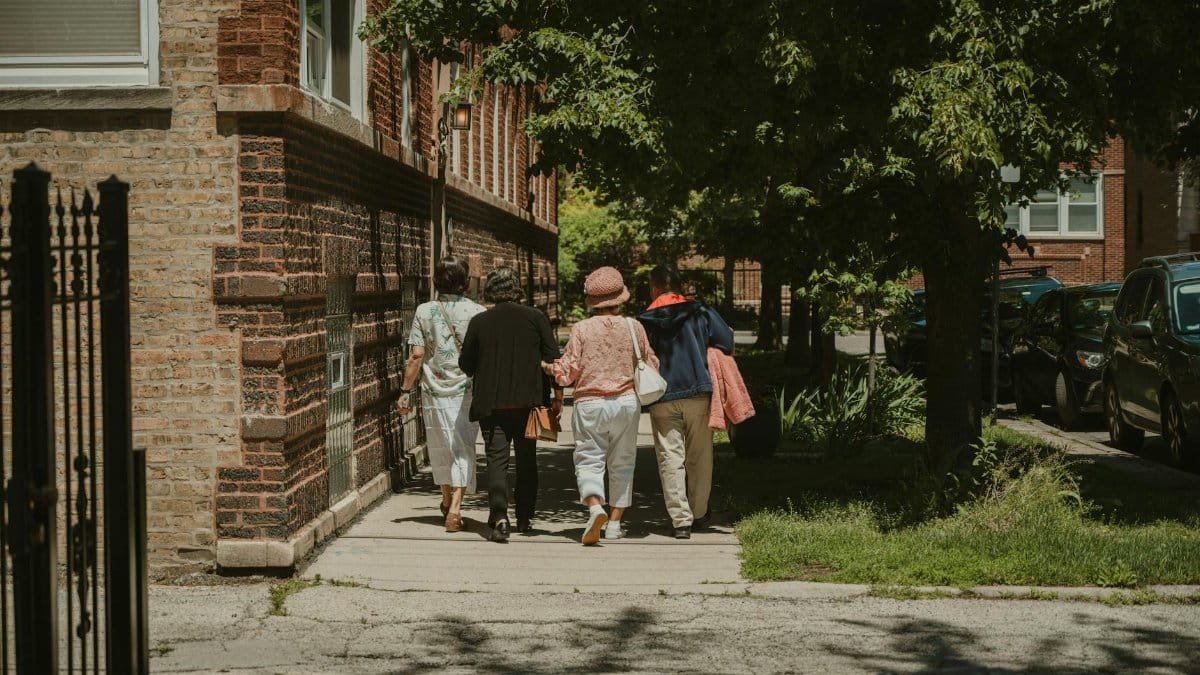 A diverse group of women walking together on a sunny day in a Chicago neighborhood street.