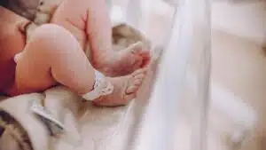 Close-up of newborn baby feet with hospital ID bracelet, symbolizing new beginnings.