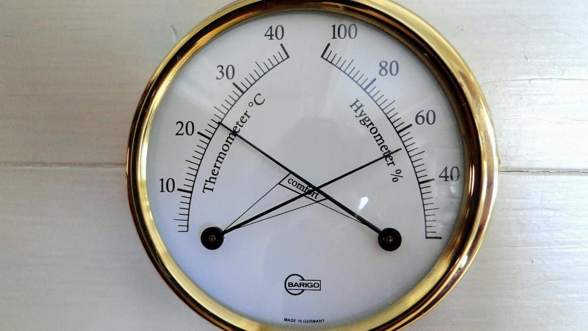 Close-up of a round analog display showing temperature and humidity.