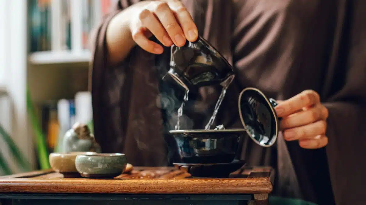 A serene close-up of a traditional tea ceremony, focusing on a teapot and pouring tea.