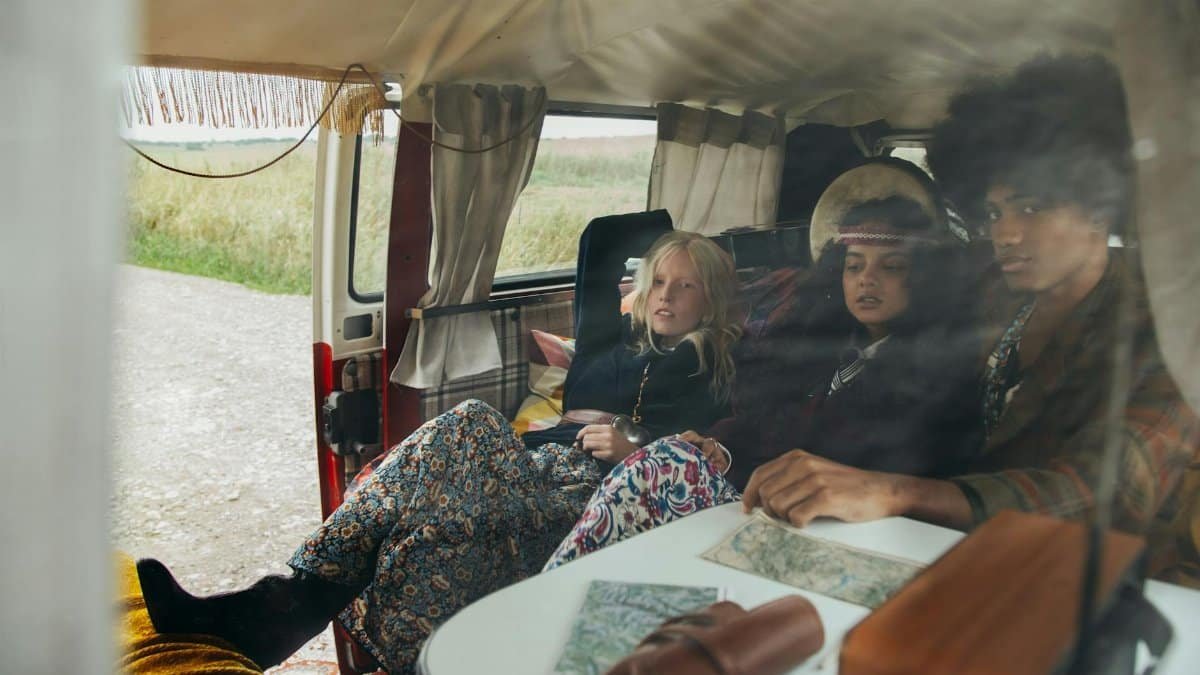 Three friends relaxing inside a retro van, symbolizing carefree travel and freedom.