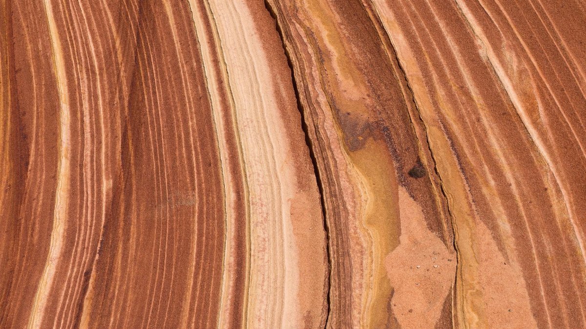 Close-up of a sandstone surface showcasing unique striations and earthy tones.