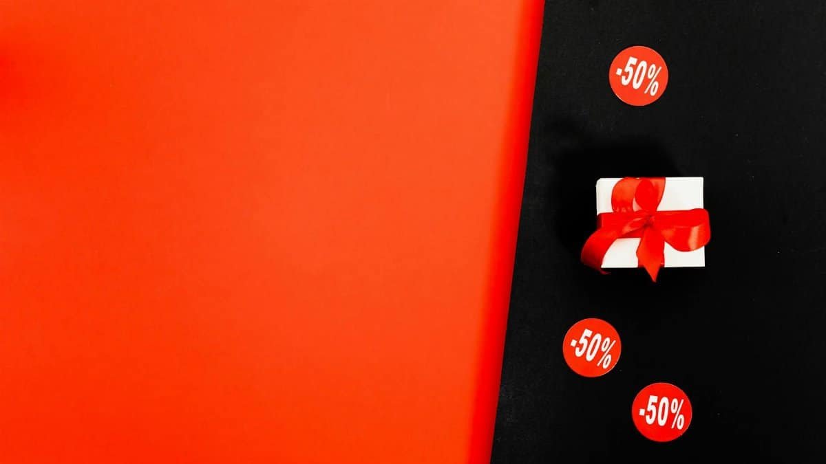Shop 50% discounts with a stylish gift box on a Black Friday sale background.