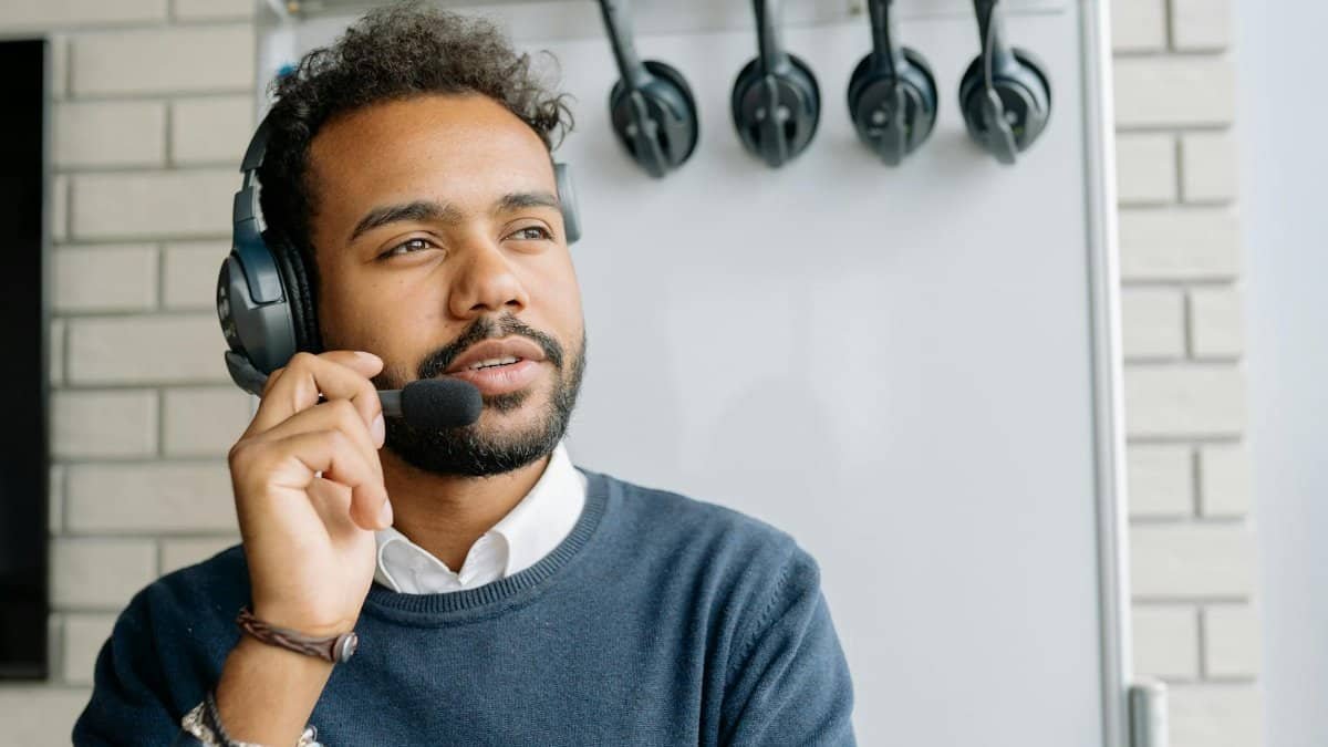A man with a headset working in a call center, looking attentively ahead.
