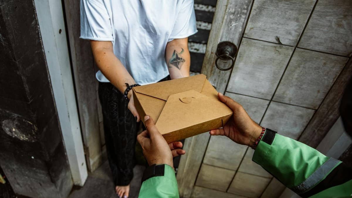 A delivery person handing over a package to a customer at their doorstep.
