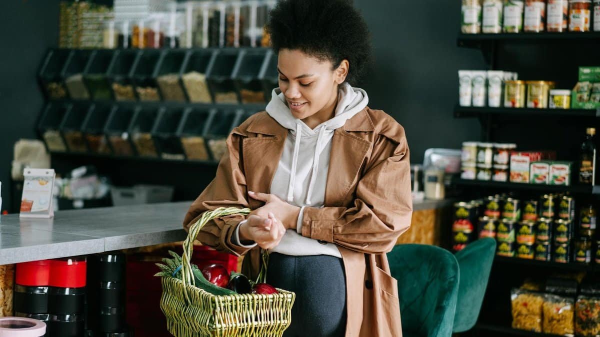 A pregnant woman shops for fresh vegetables at an organic grocery store.