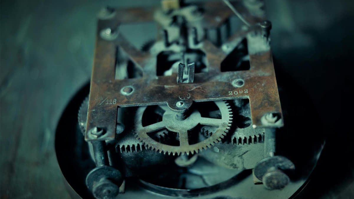 Close-up photo of an old rusty clock mechanism showcasing intricate gears and machinery.