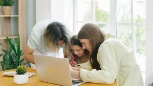 Parents helping their child with homework while sitting together at a table.