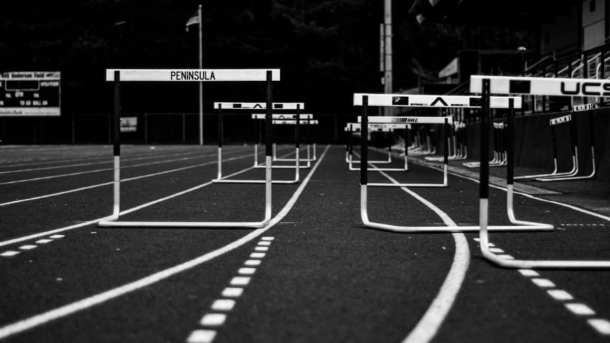 Monochrome image of hurdles on an empty sports track, perfect for athletic themes.