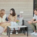 A family enjoying a relaxing day on their patio, engaging with digital devices.