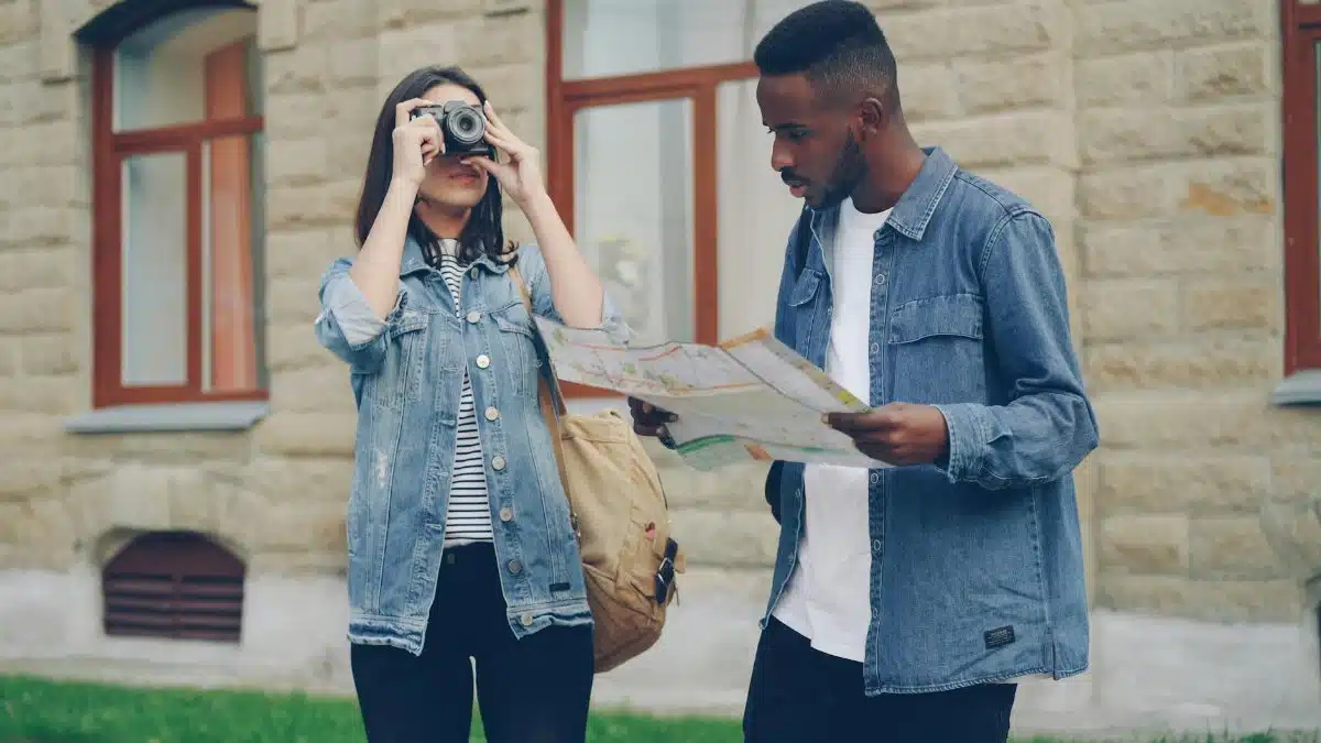 Two young adults exploring urban settings with a map and camera, showcasing travel adventures.