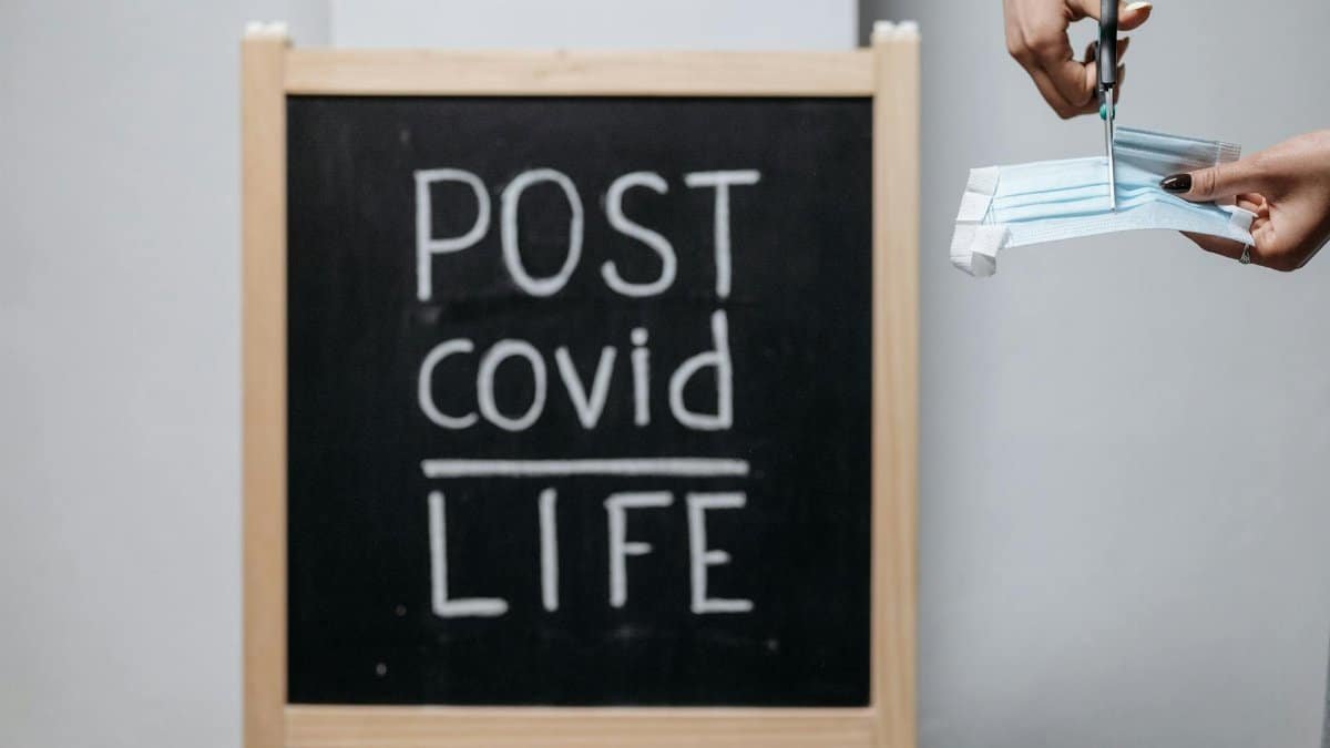 Chalkboard message with a mask cutting symbolizes transition to post-COVID life.