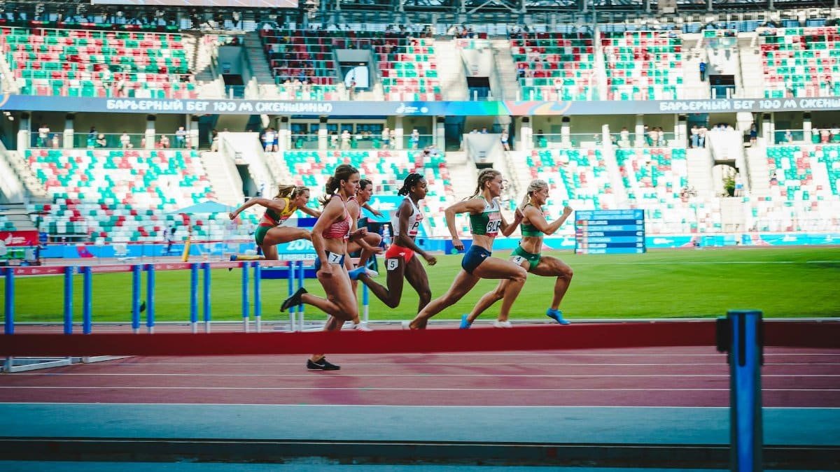 Athletes compete in an intense women's hurdles event at Minsk stadium, showcasing speed and agility.