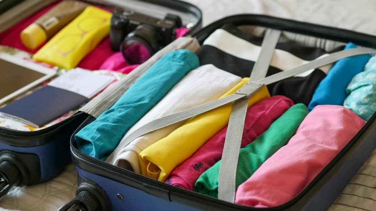 Open suitcase neatly packed with colorful clothes and travel essentials.